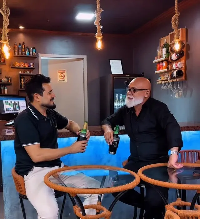 Cantinho de bebidas com mesa e cadeiras dentro da barbearia