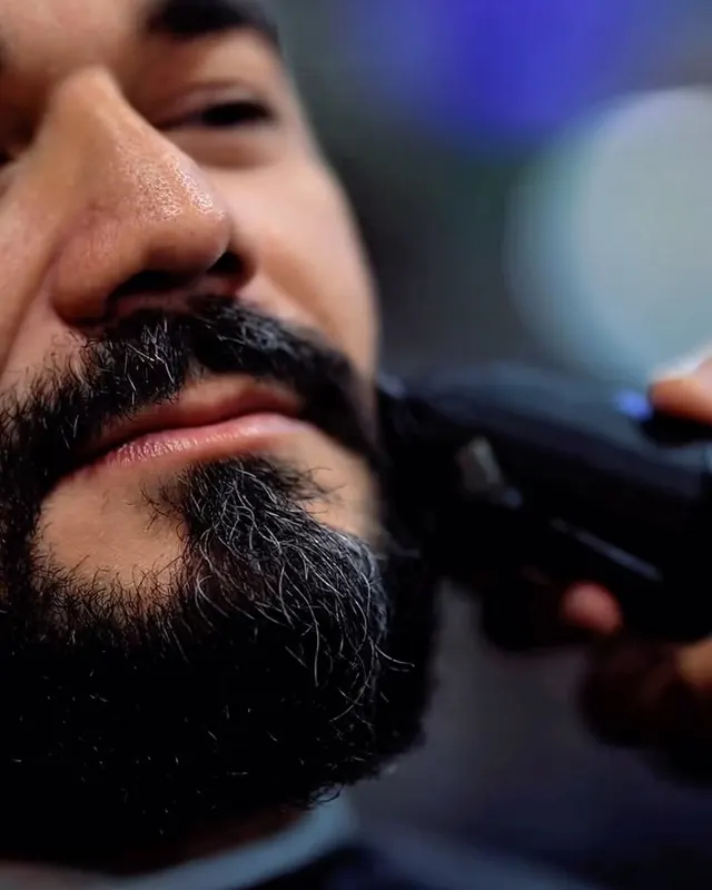 Barba escura sendo finalizada na máquina