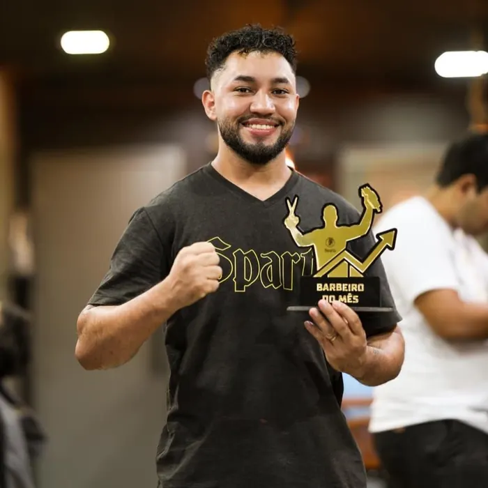 Outro barbeiro da equipe com o troféu de barbeiro do mês