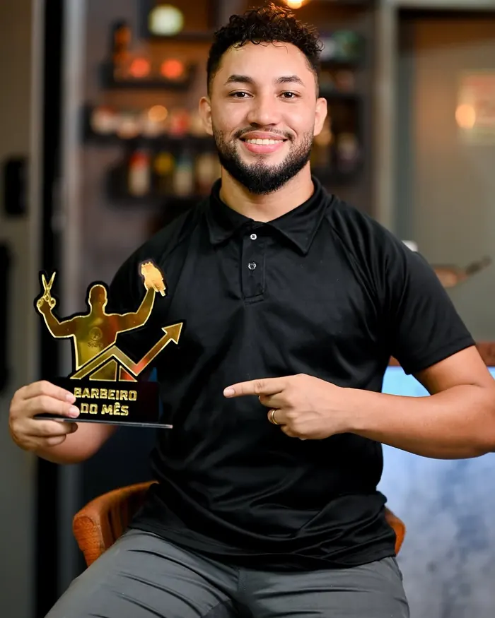 Barbeiro da Sparta segurando o troféu de barbeiro do mês