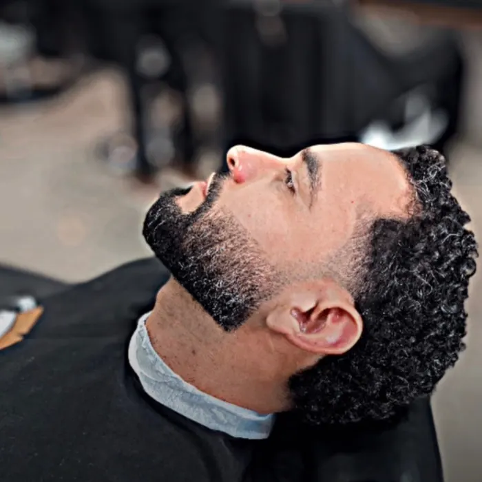Barba desenhada e cabelo cacheado